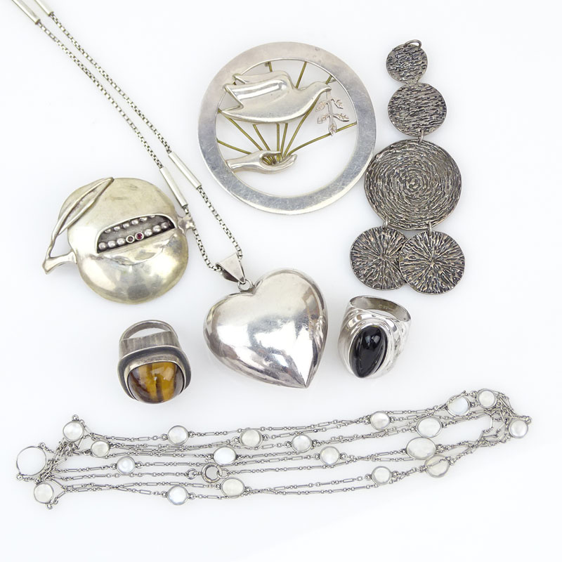 Seven (7) Piece Sterling Silver Jewelry Lot Including: One Necklace with Moonstones; A Necklace with Heart Pendant; A Modern Design Five Circle Pendant; A Ring with Tiger-eye; A Ring with Onyx; A Brooch with Dove; A Persimmon Brooch