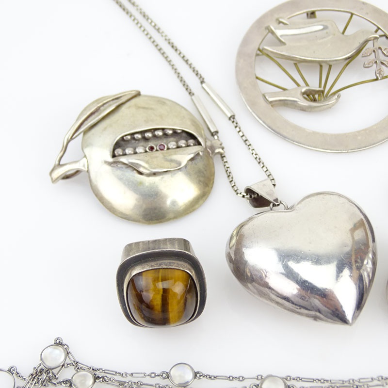 Seven (7) Piece Sterling Silver Jewelry Lot Including: One Necklace with Moonstones; A Necklace with Heart Pendant; A Modern Design Five Circle Pendant; A Ring with Tiger-eye; A Ring with Onyx; A Brooch with Dove; A Persimmon Brooch