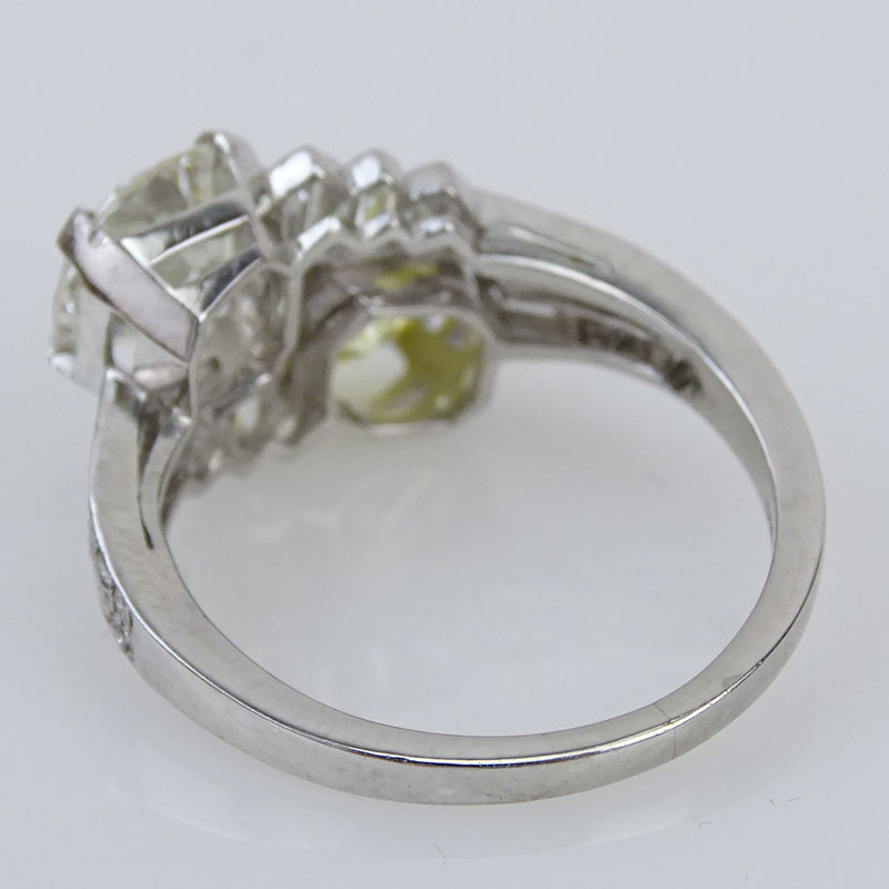 1.85 Carat Round Brilliant Cut Fancy Intense Yellow Diamond and an Approx. 1.70 Carat Round Brilliant Cut Diamond and Platinum Two Stone Crossover Ring.