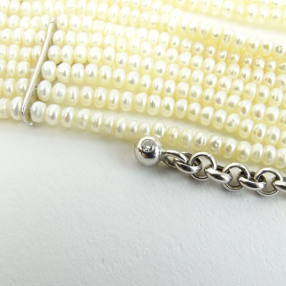 18 Karat White Gold and 10 Strand White Pearl Choker Necklace accented with small round cut diamonds.