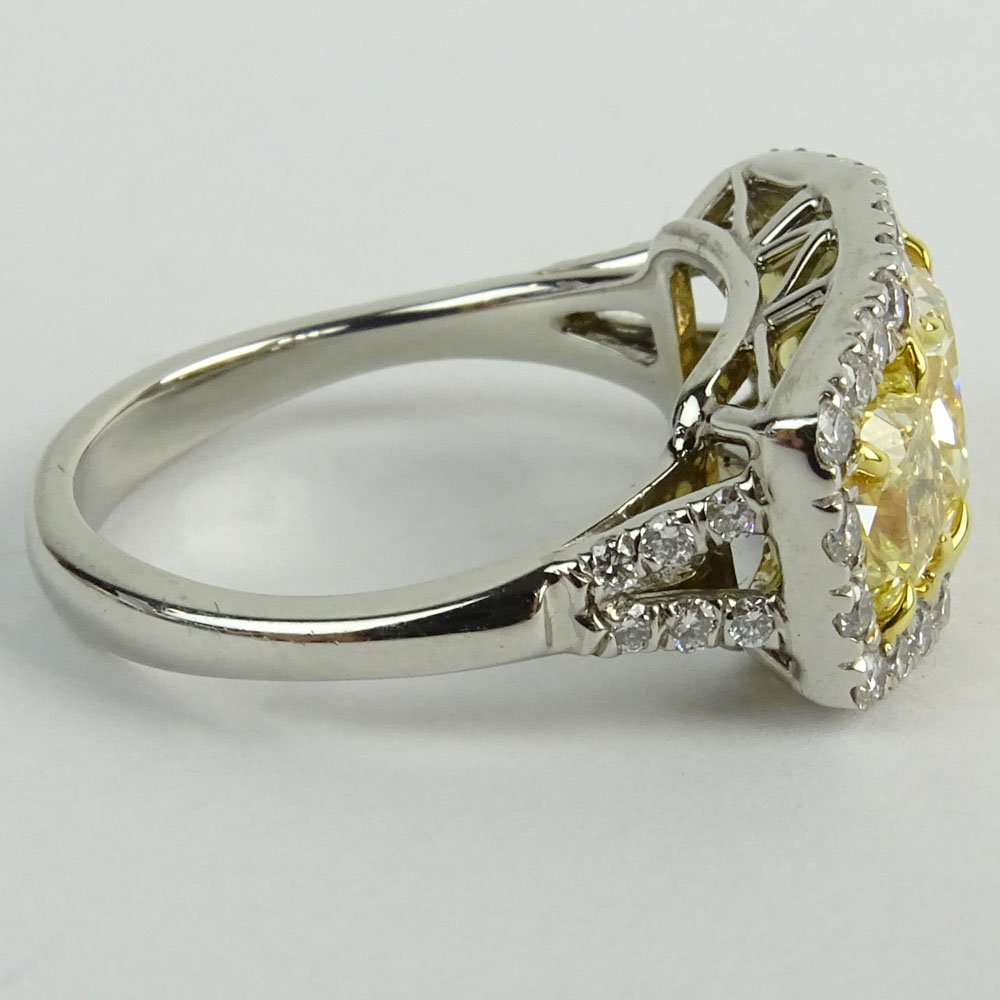 Approx. 3.0 Carat Cushion Cut Fancy Yellow Diamond, Platinum and 18 Karat Yellow Gold Three Stone Ring.