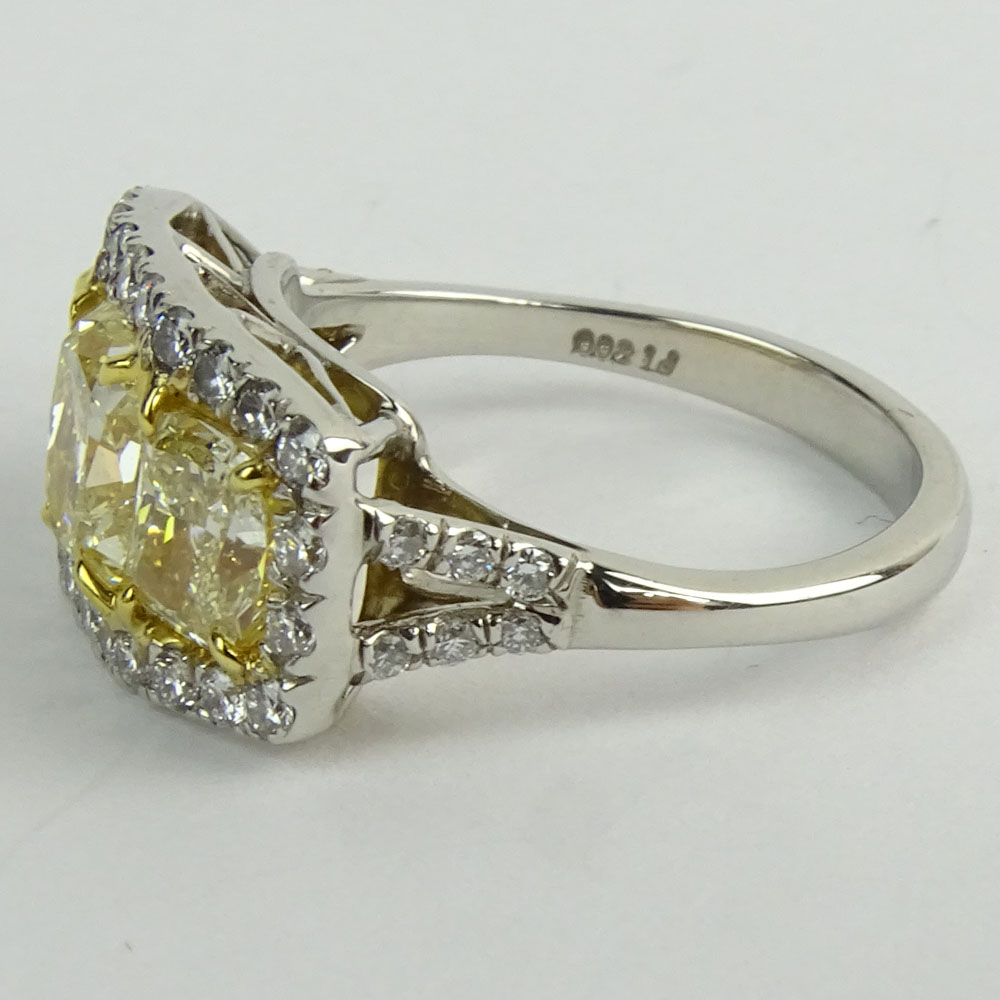 Approx. 3.0 Carat Cushion Cut Fancy Yellow Diamond, Platinum and 18 Karat Yellow Gold Three Stone Ring.