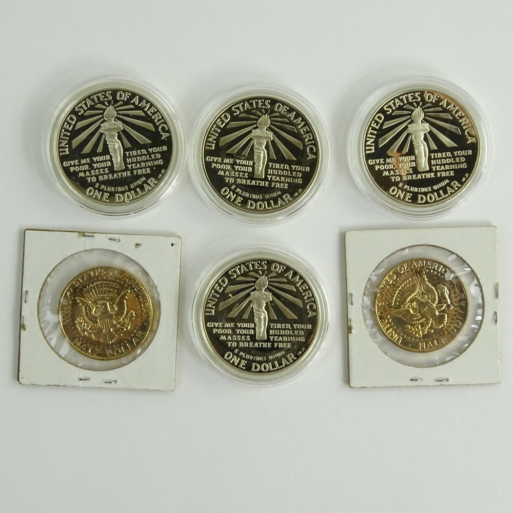 Lot of Four (4) 1986 Ellis Island Commemorative One Dollar Coins and Two (2) 1982 Gold Washed Kennedy Half Dollars.