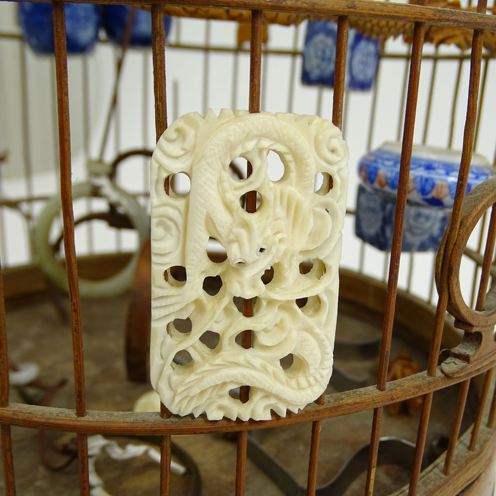 Early 20th Century Chinese Carved Wood Hanging Birdcage with Blue and White Porcelain Feeders, Jade Swings and Carved Ivory Ornaments Together with Attached Cricket Cage.