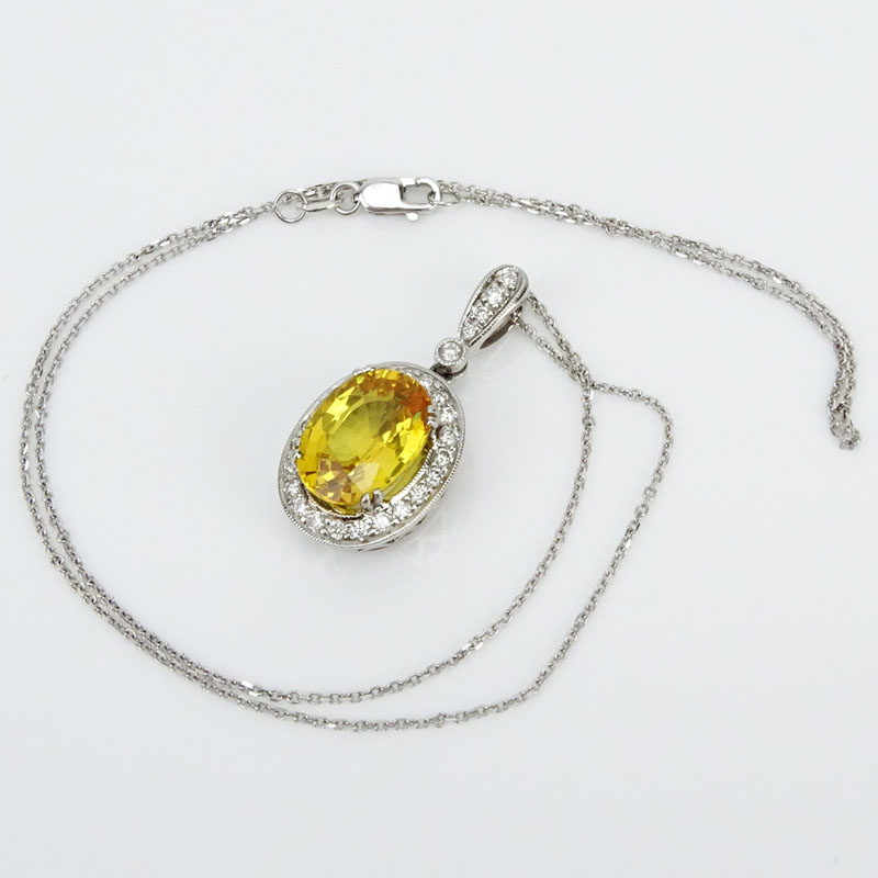 Approx. 6.50 Carat Oval Cut Yellow Sapphire, .63 Carat Diamond and 18 Karat White Gold Pendant with 14 Karat White Gold Chain.