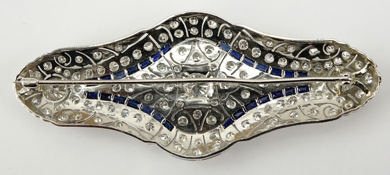 1920s Art Deco Approx. 6.0 Carat TW Round Cut Diamond, 1.0 Carat Caliber Cut Sapphire and Platinum Brooch.