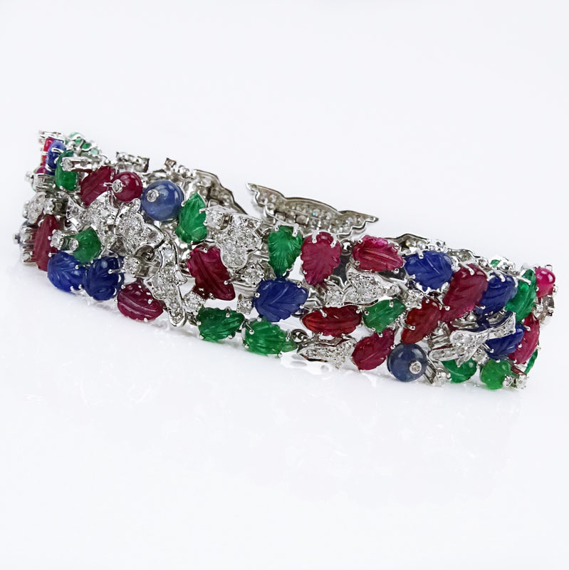 Cartier style 55.50 Carat Carved Emerald, Ruby and Sapphire and 9.15 Carat Round Brilliant Cut Diamond and 18 Karat White Gold Tutti Frutti Bracelet. 