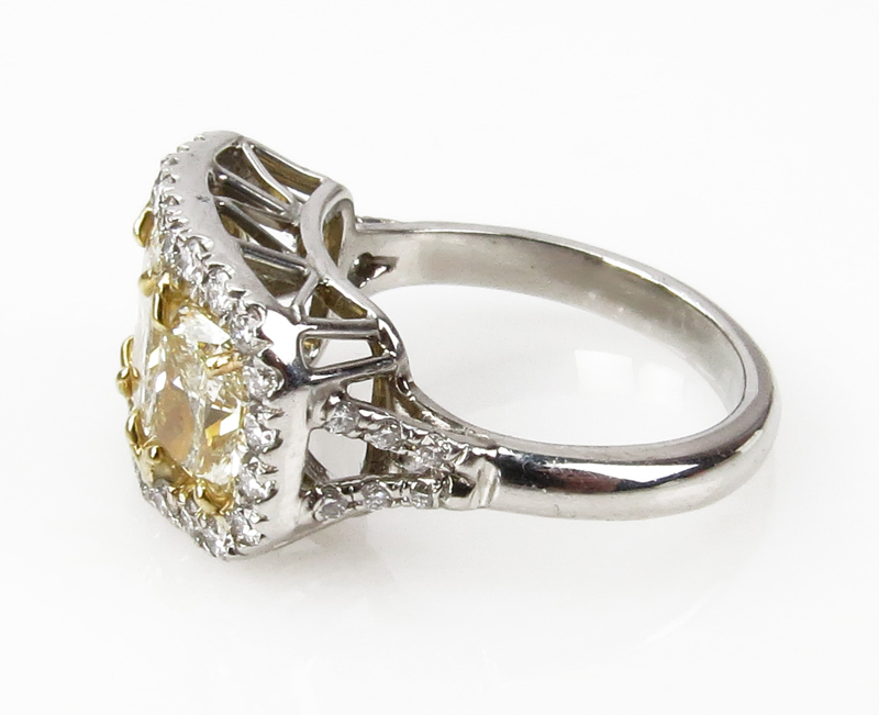 EGL Certified 2.91 Carat Radiant Cut Fancy Light Yellow Diamond and Platinum Three Stone Ring accented throughout with .72 Carat Round Brilliant Cut Diamonds.