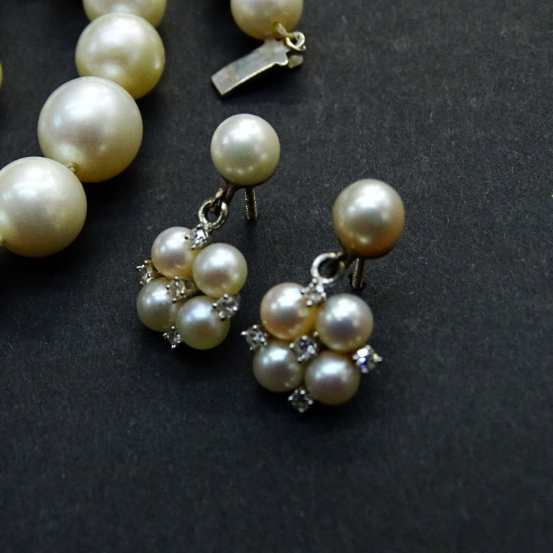 Vintage Single Strand 7.5mm-10.0mm White Pearl Necklace with 14 Karat White Gold Clasp and with Matching Earrings Accented with Small Round Cut Diamonds.