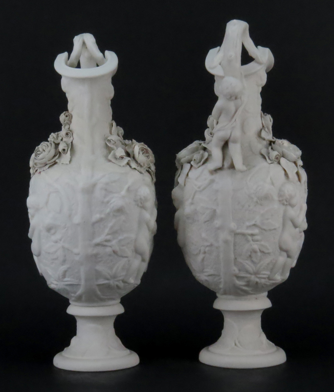 Pair of Victorian Style Bisque Porcelain Putti Figural Relief Ewers
