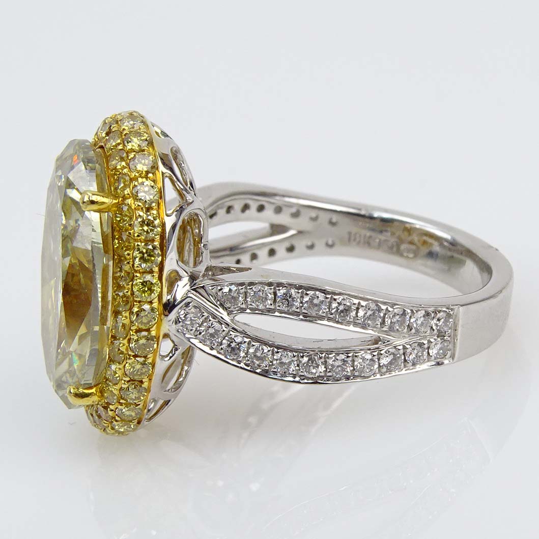 GIA Certified 7.04 Carat Oval Brilliant Cut Fancy Gray-Greenish Yellow Diamond and 18 Karat Yellow and White Gold Engagement Ring accented throughout with Fancy Yellow and White Diamonds.