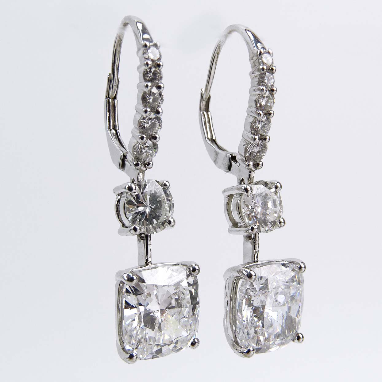 GIA Certified Approx. 7.07  Carat TW Cushion Cut Diamond and 18 Karat White Gold Pendant Earrings Accented with Round Brilliant Cut Diamonds.