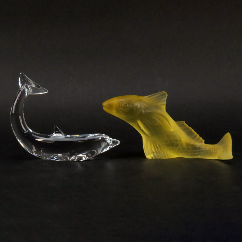 Grouping of Two (2) Baccarat Crystal Figurines/Paperweights. Includes: clear crystal "Swimming" dolphin figurine and yellow frosted crystal "Gadideo" fish. 