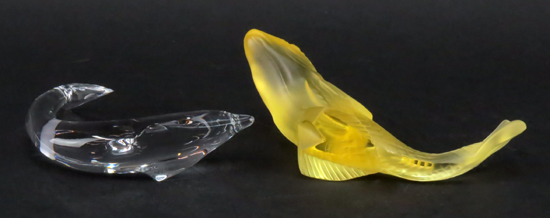 Grouping of Two (2) Baccarat Crystal Figurines/Paperweights. Includes: clear crystal "Swimming" dolphin figurine and yellow frosted crystal "Gadideo" fish. 