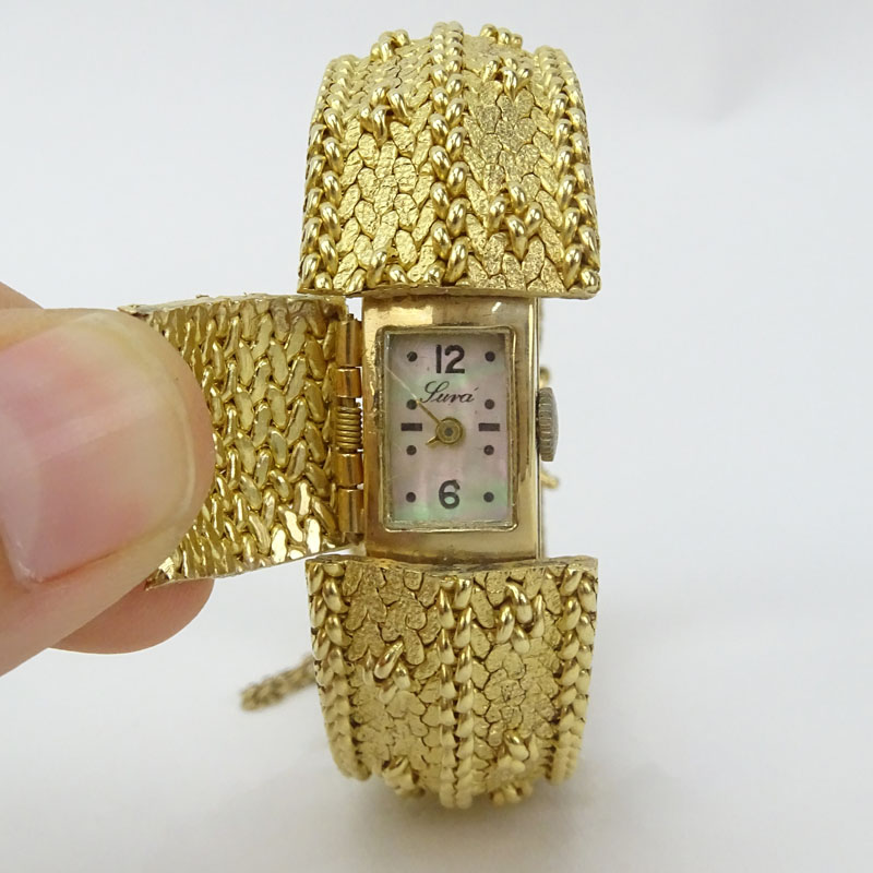 Vintage Luva 14 Karat Yellow Gold Flip Top Bracelet Watch with Mother of Pearl Dial and Manual Movement.