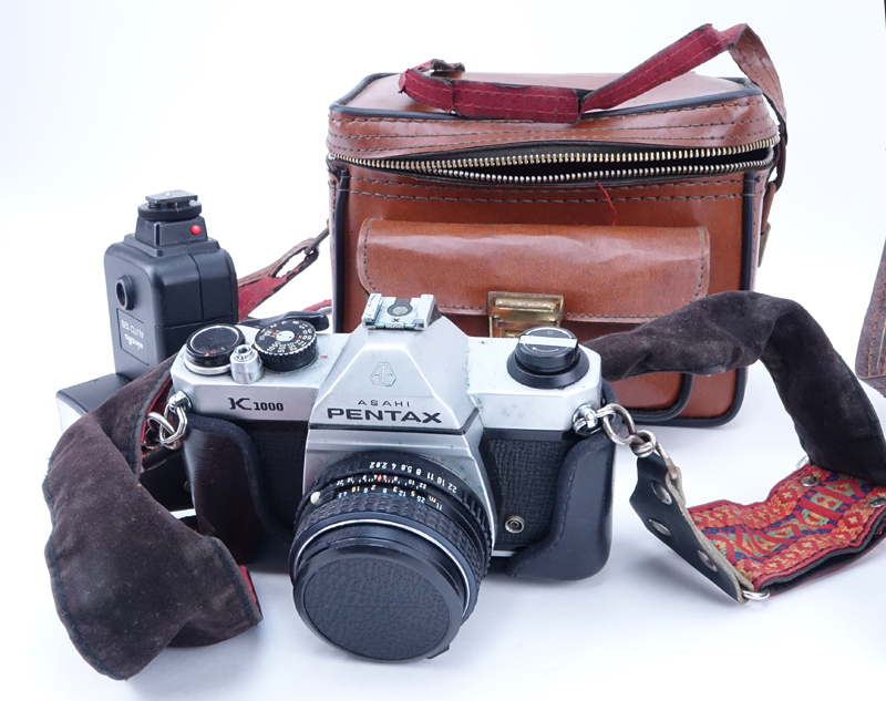 Grouping of Pentax K1000 and Pentax Auto 110 Film Cameras in Leather Traveling Cases.