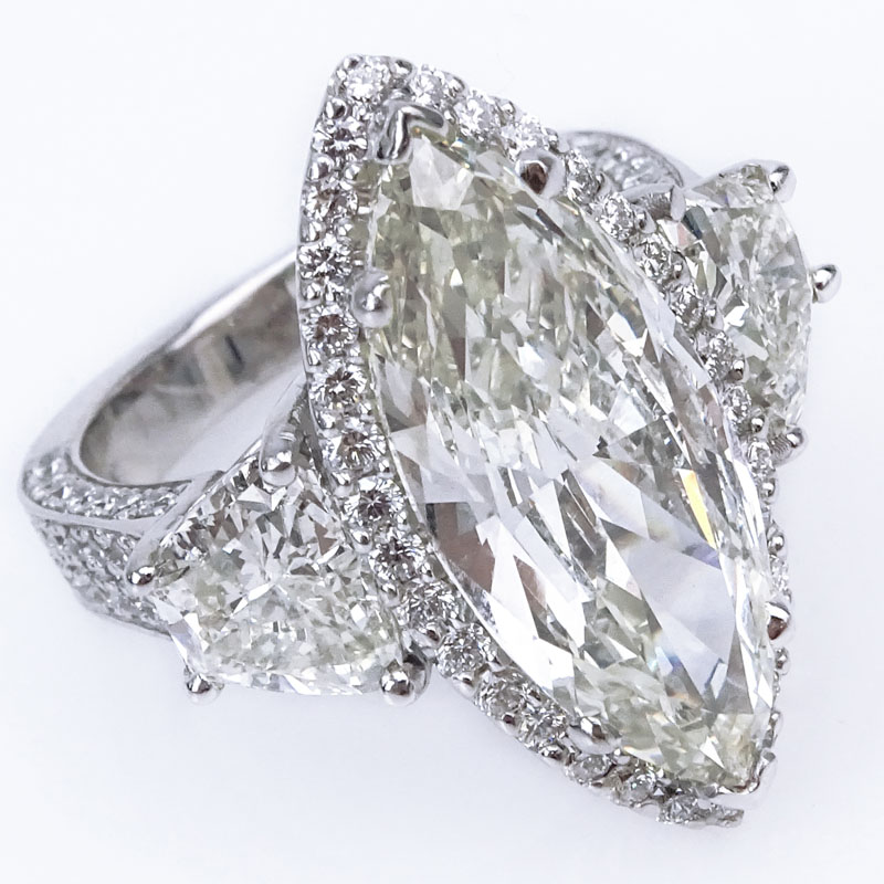 Approx. 10.64 Carat TW Diamond and 14 Karat White Gold Engagement Ring Set in the Center with a 6.64 Carat Marquise Cut Diamond and Accented with Two Trapezoid Cut and further accented with Round Brilliant Cut Diamonds.