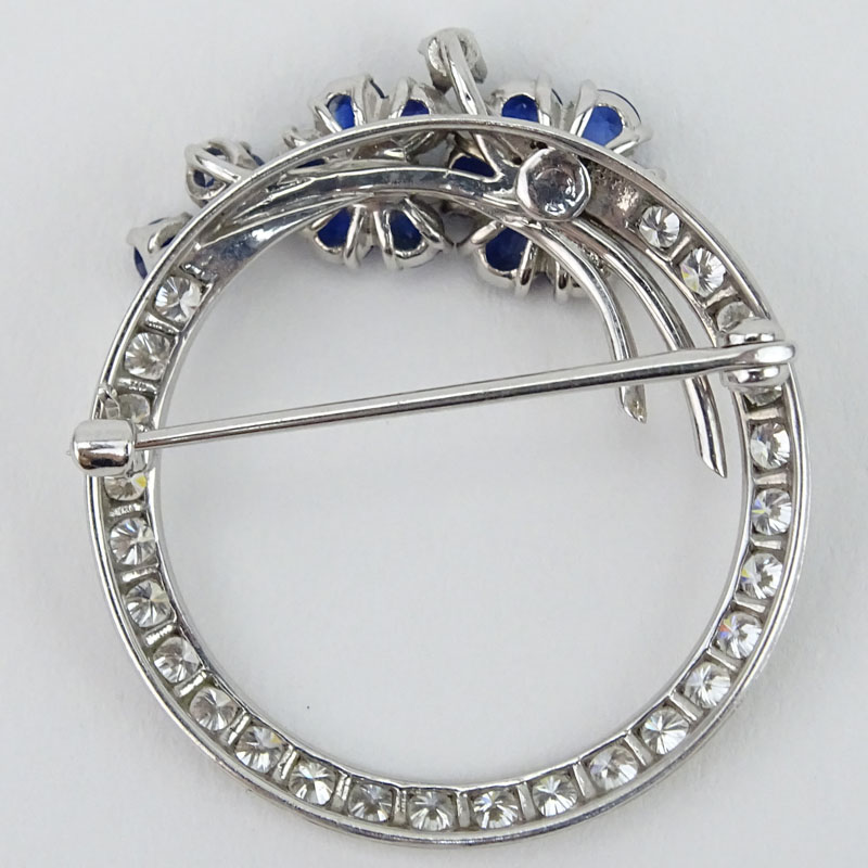 Vintage Approx. 1.0 Carat Round Brilliant Cut Diamond, Sapphire and 18 Karat White Gold Circle Brooch. Diamonds H color, VS1 clarity. Sapphires with vivid saturation of color. 