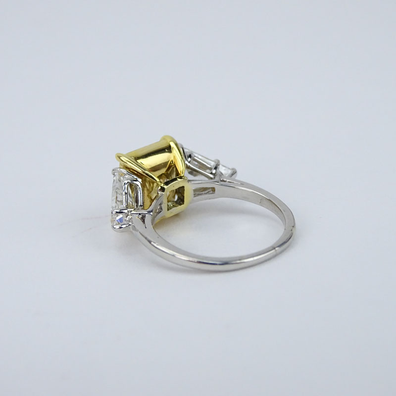 GIA Certified 4.29 Carat Emerald Cut Fancy Yellow Diamond, 1.81 Carat TW Trillion Cut White Diamond, Platinum and 18 Karat Yellow Gold Engagement Ring. 