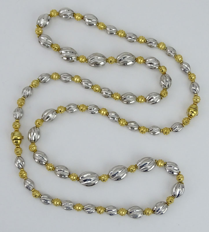 Long Single Strand 18 Karat Yellow and White Gold Graduated Bead Necklace.