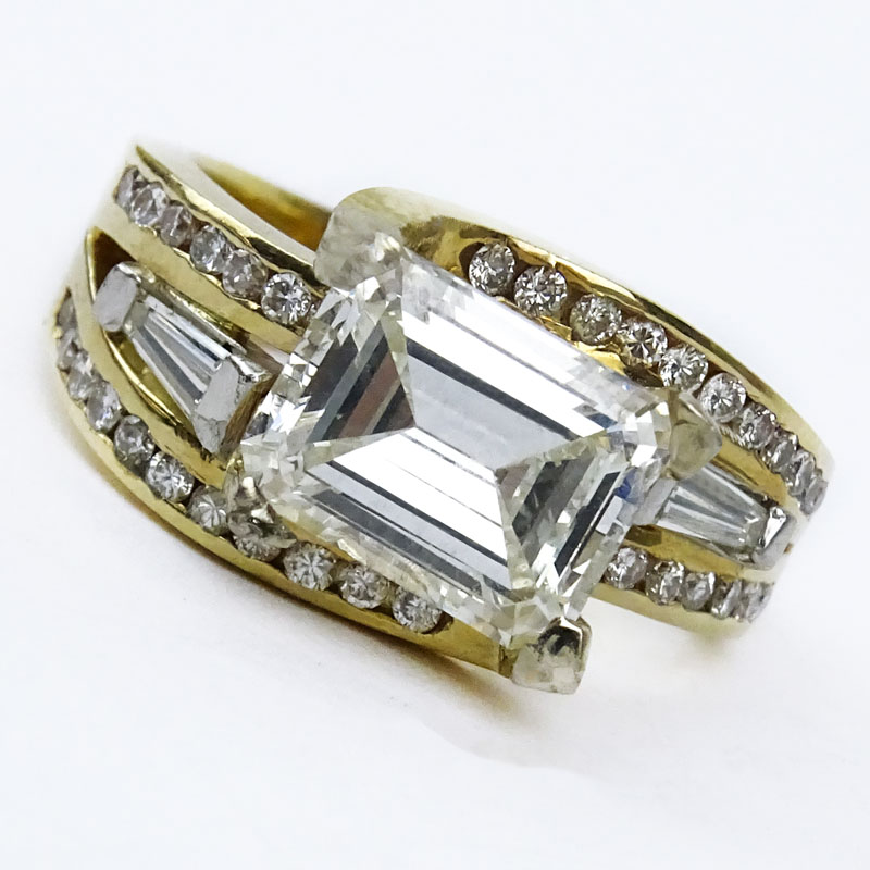 Approx. 3.0 Carat Emerald Cut Diamond and 14 Karat Yellow Gold Ring accented throughout with Baguette and Round Brilliant Cut Diamonds.