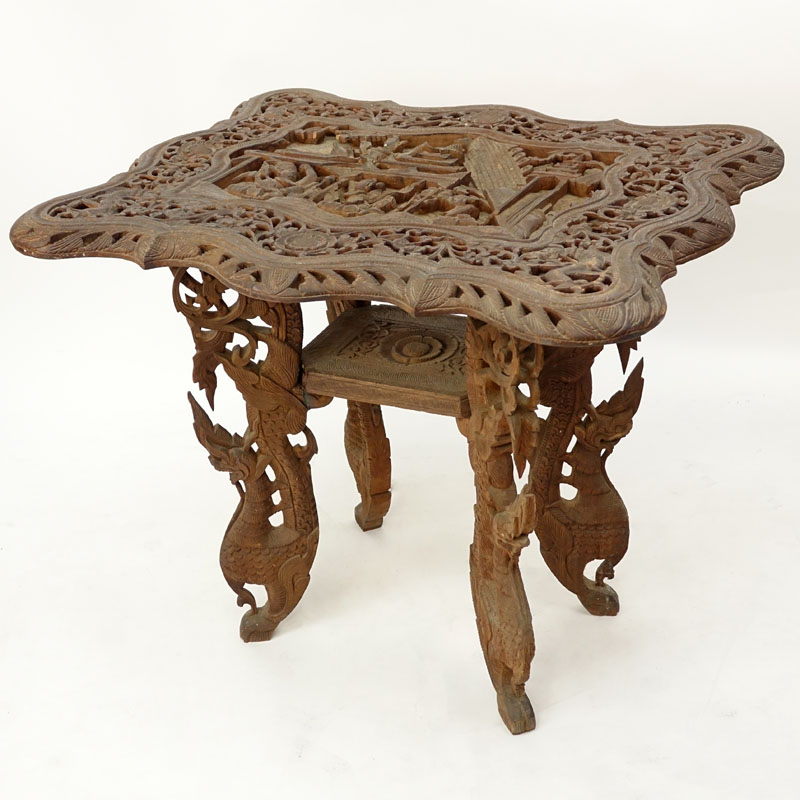 20th Century Thai Carved Teak Wood Table. Relief carving to top, pierced border, and stands on dragon figural legs. 