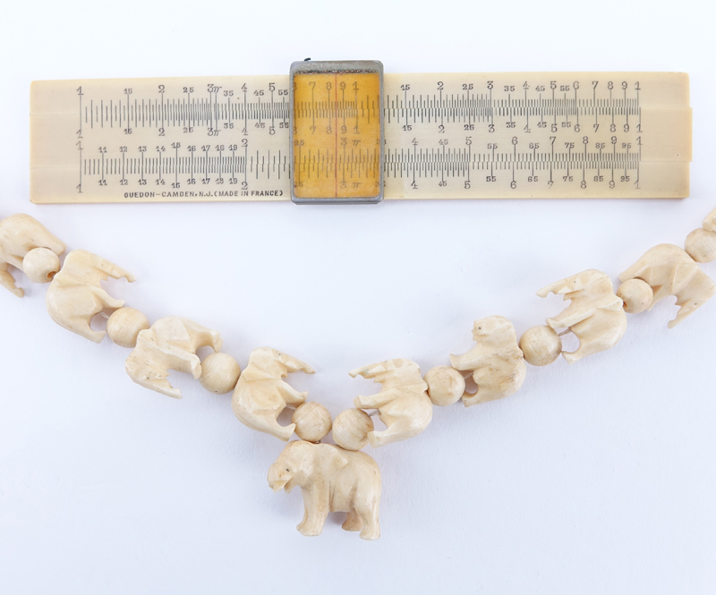 Collection of Four (4) Carved Ivory Objects. Includes 2 fans, slide rule, elephant necklace. 