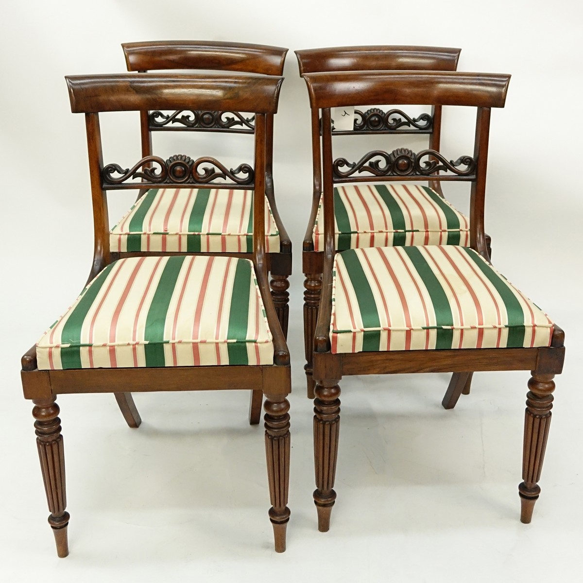 Set of Four (4) Antique English Regency style Carved Mahogany and Upholstered Side Chairs. Pierced splats and stands on tapered legs with molded front legs.