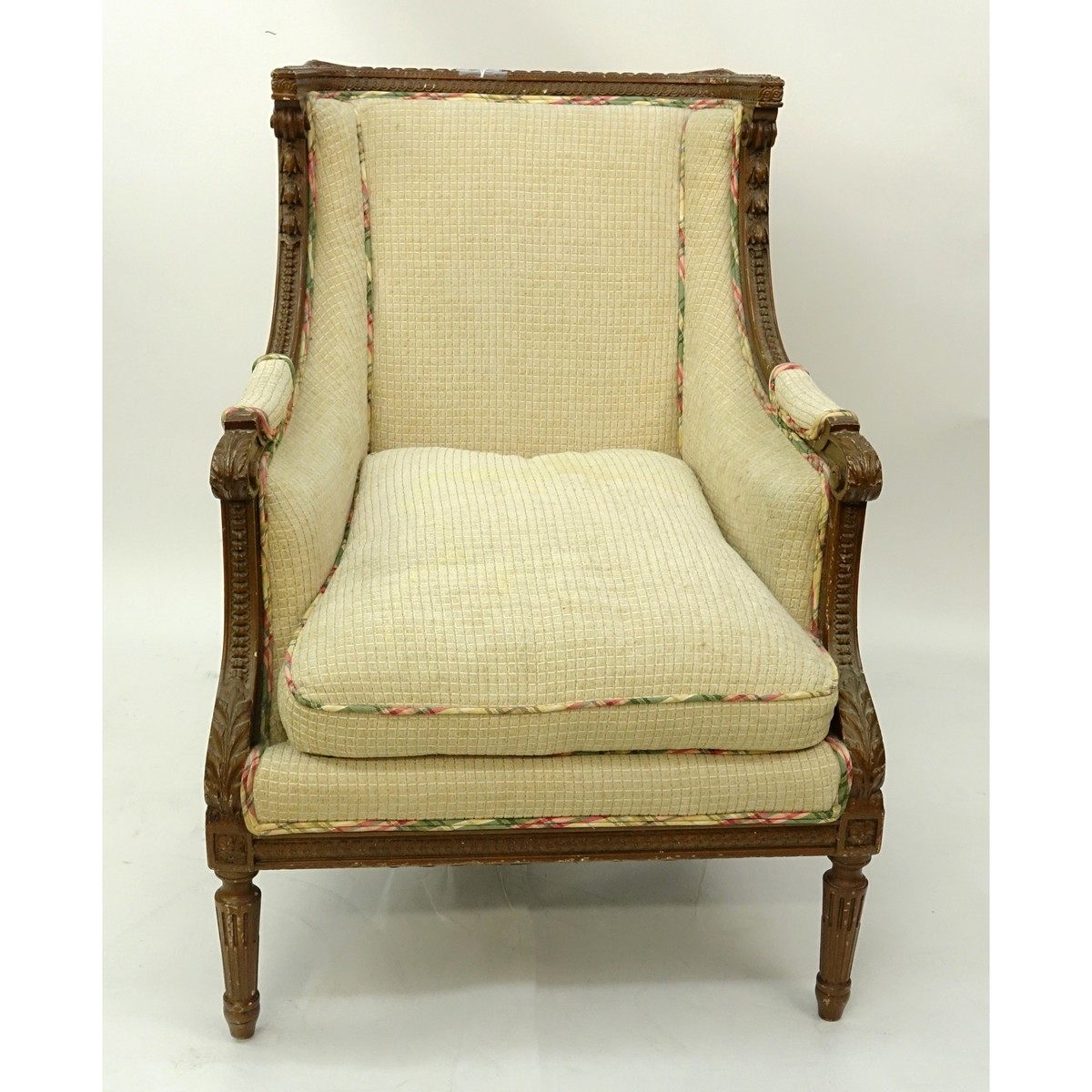 19/20th Century French Louis XVI Style Carved Wood and Upholstered Bergere. Neoclassical details of florals and fluted legs.