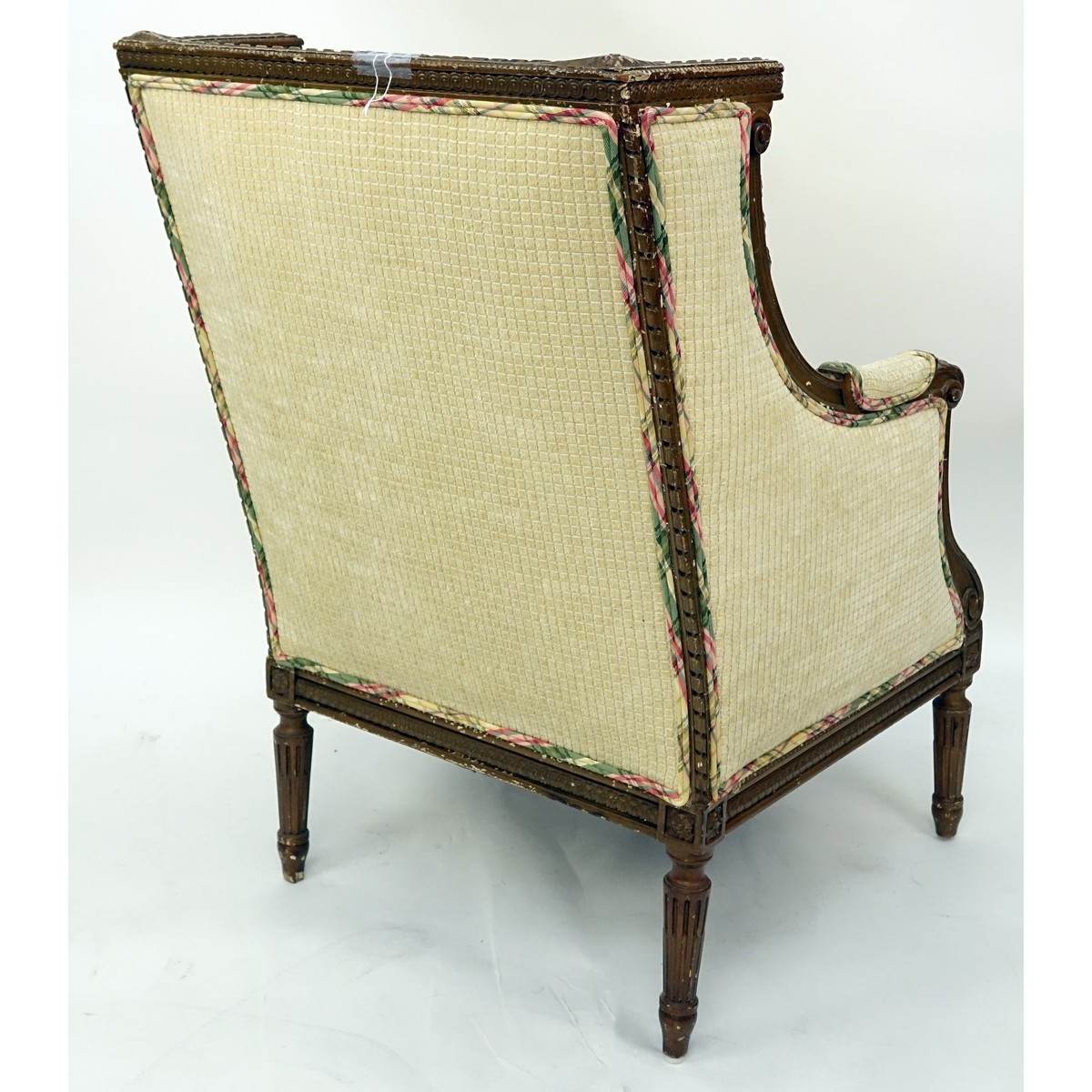 19/20th Century French Louis XVI Style Carved Wood and Upholstered Bergere. Neoclassical details of florals and fluted legs.