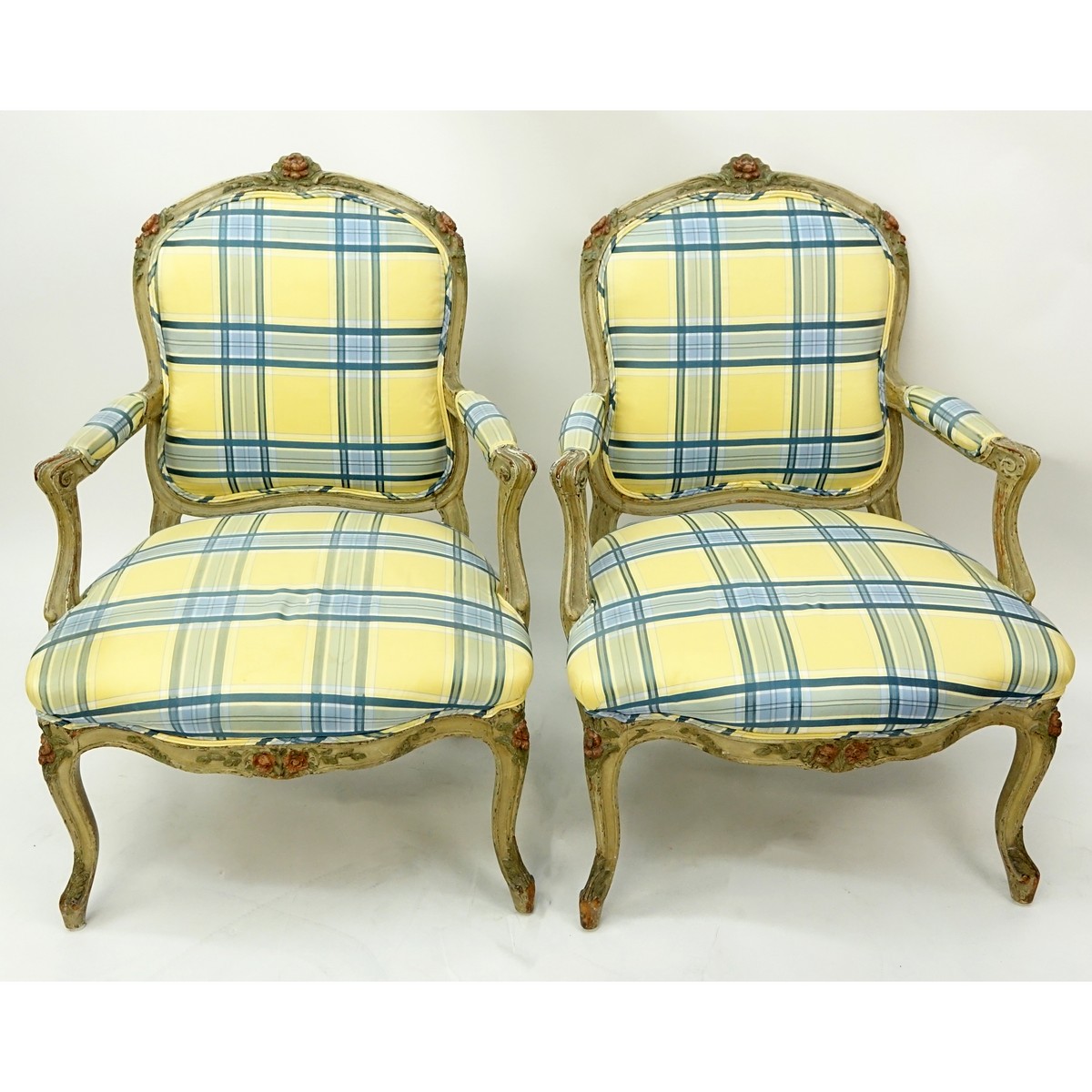 Pair of 18/19th Century French Carved Wood and Upholstered Fauteuils. Painted floral accents to frame, stands on cabriole legs.