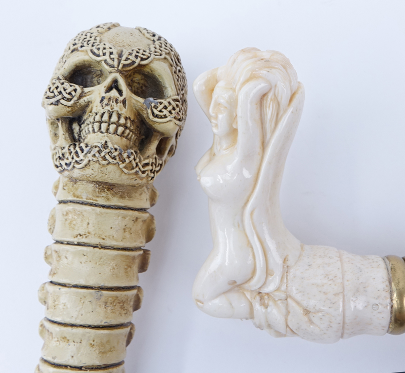 Two (2) walking Sticks. One with carved nude top and one with composition skull top.