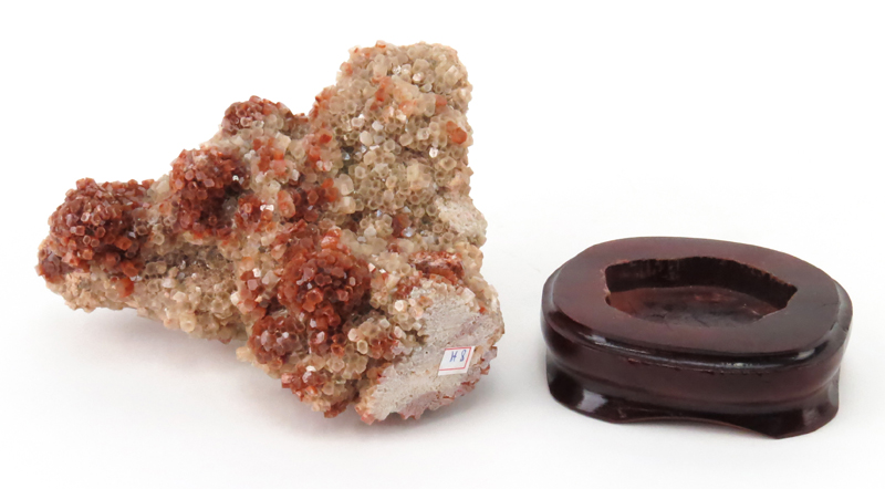 Vanadinite Mineral Specimen on Wooden Stand. Sphered structure with faceted crystals, pale and dark brown color.