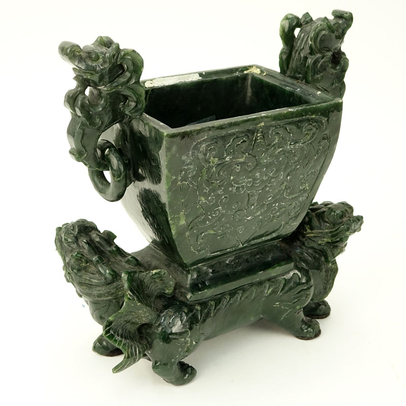 Early to Mid 20th Century Chinese Carved Jade Foo Lion Urn. Carved floral relief to front and obverse side, mock ring handles, and molded foo lion base.