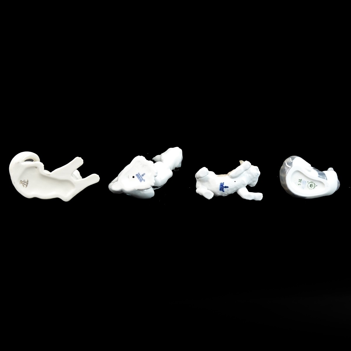 Four Playful Porcelain Cat Figurines